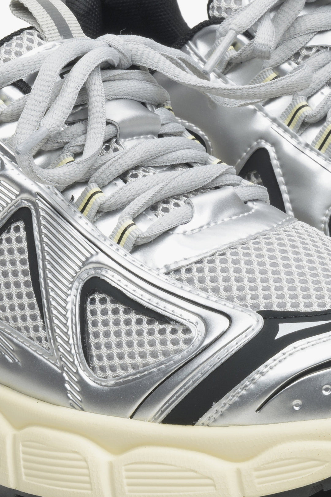 Damskie srebrno-czarne sneakersy na elastycznej platformie - zbliżenie na linię sznurowania buta.