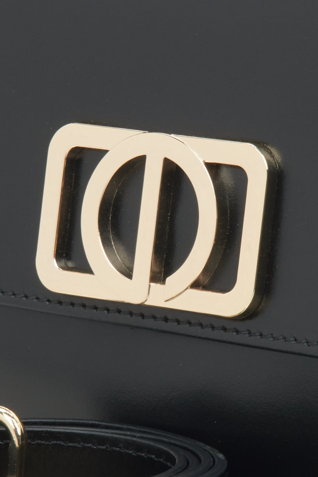 Kobieca torebka w odcieniu czarnym, o kompaktowym rozmiarze, w stylu bagietki - zbliżenie na detal.