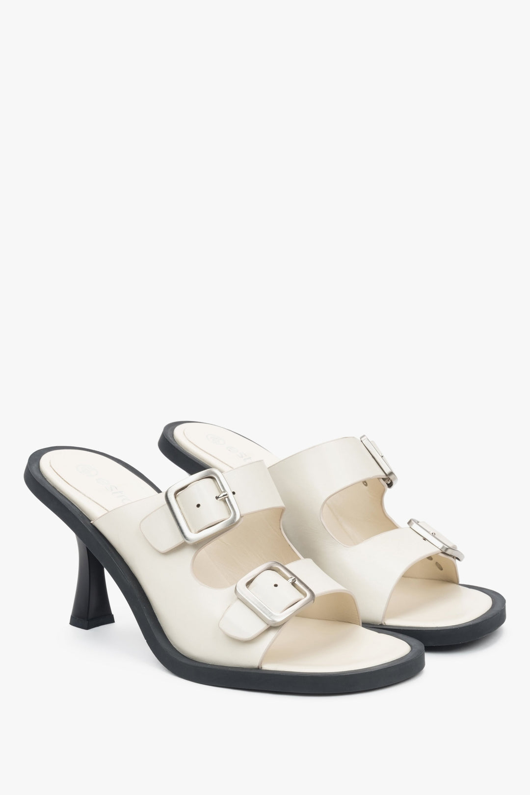 Skórzane, białe klapki damskie na szpilce Estro z klamrą - prezentacja czubka i boku obuwia.