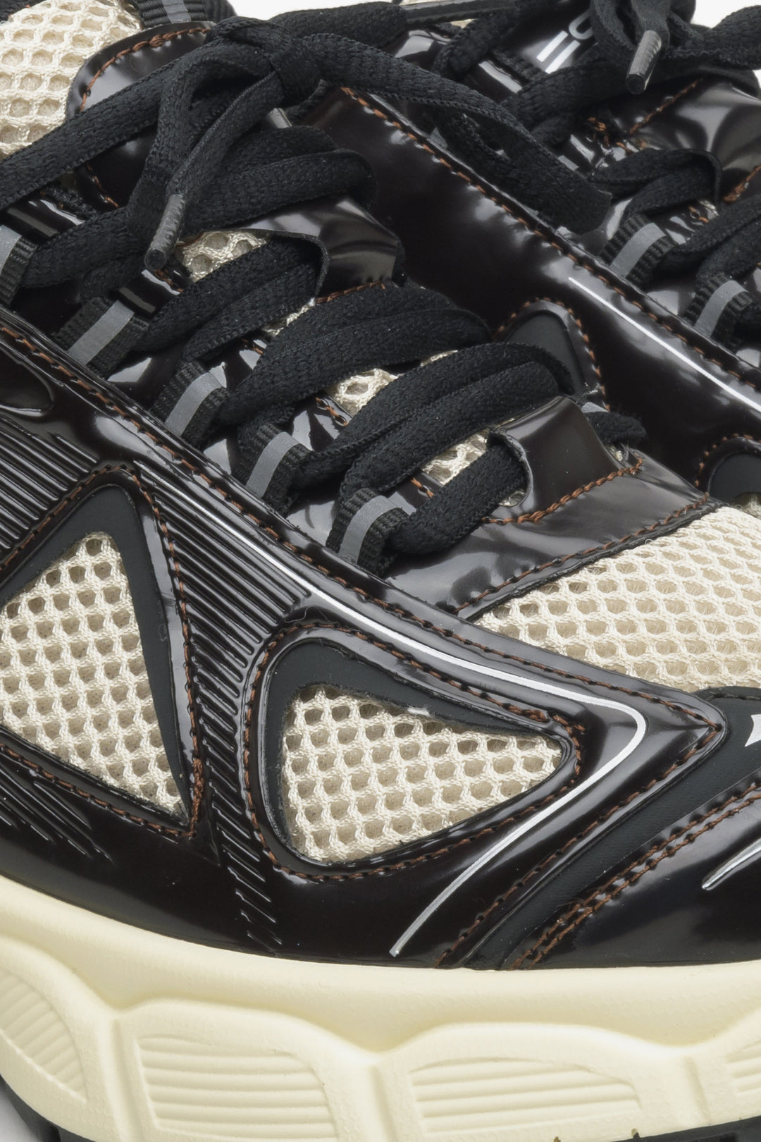 Damskie czarno-beżowe sneakersy na elastycznej platformie - zbliżenie na linię sznurowania buta.