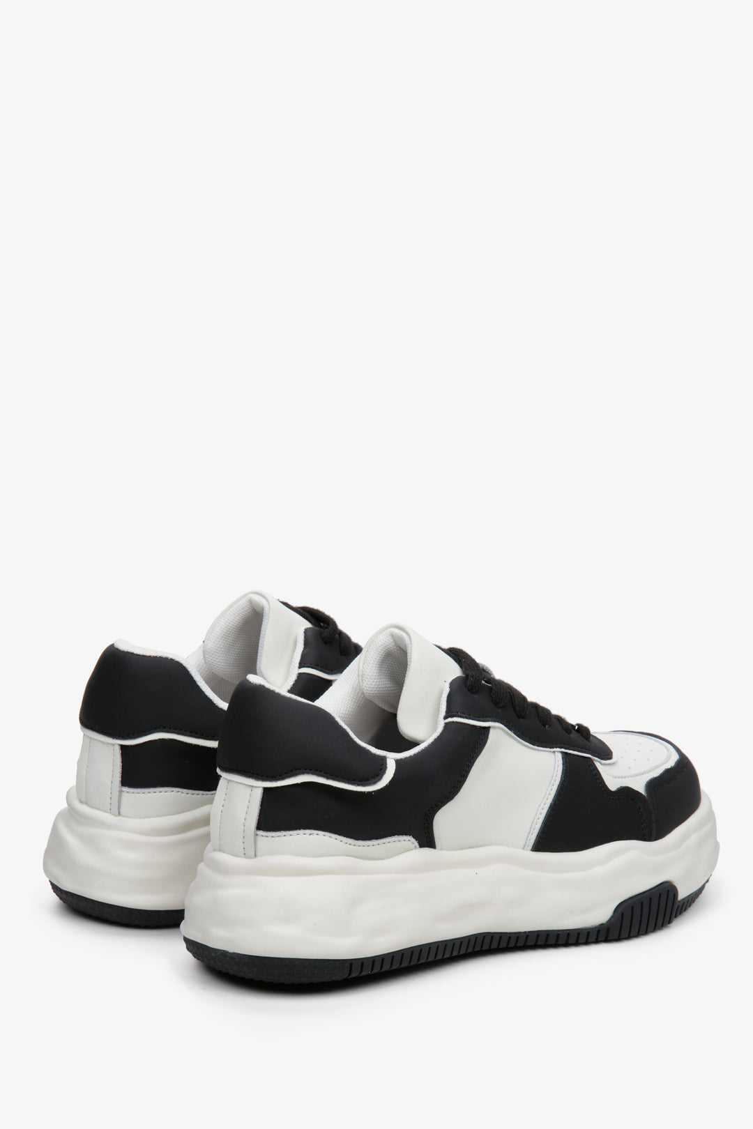 Skórzane, czarno-białe sneakersy Estro - zbliżenie na zapiętek i linię boczną butów.