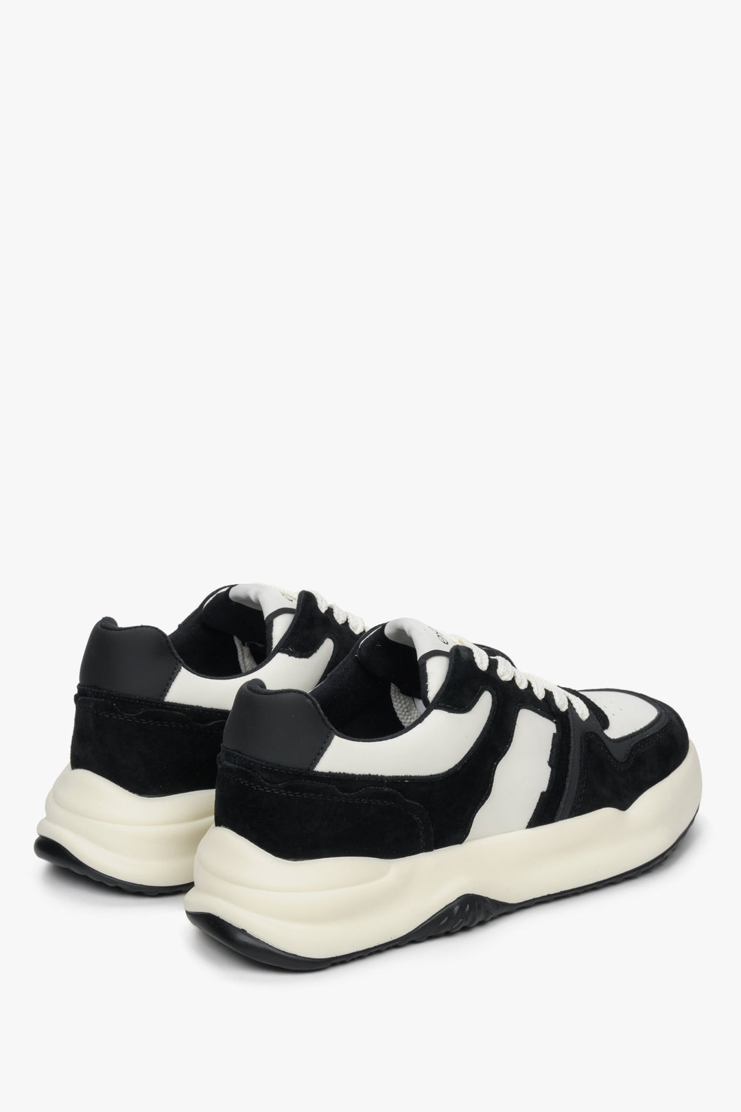 Sneakersy damskie ze skóry naturalnej i weluru - zbliżenie na zapiętek i przyszwę boczną butów w kolorze biało-czarnym.