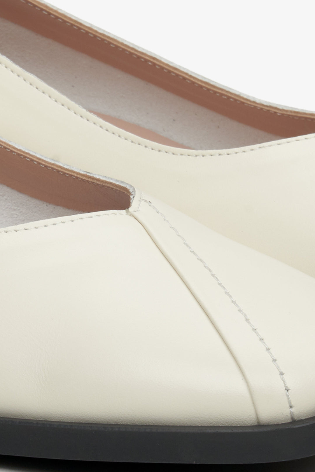 Damskie, skórzane mokasyny na obcasie Estro - zbliżenie na system przeszyć modelu w kolorze beżowym.