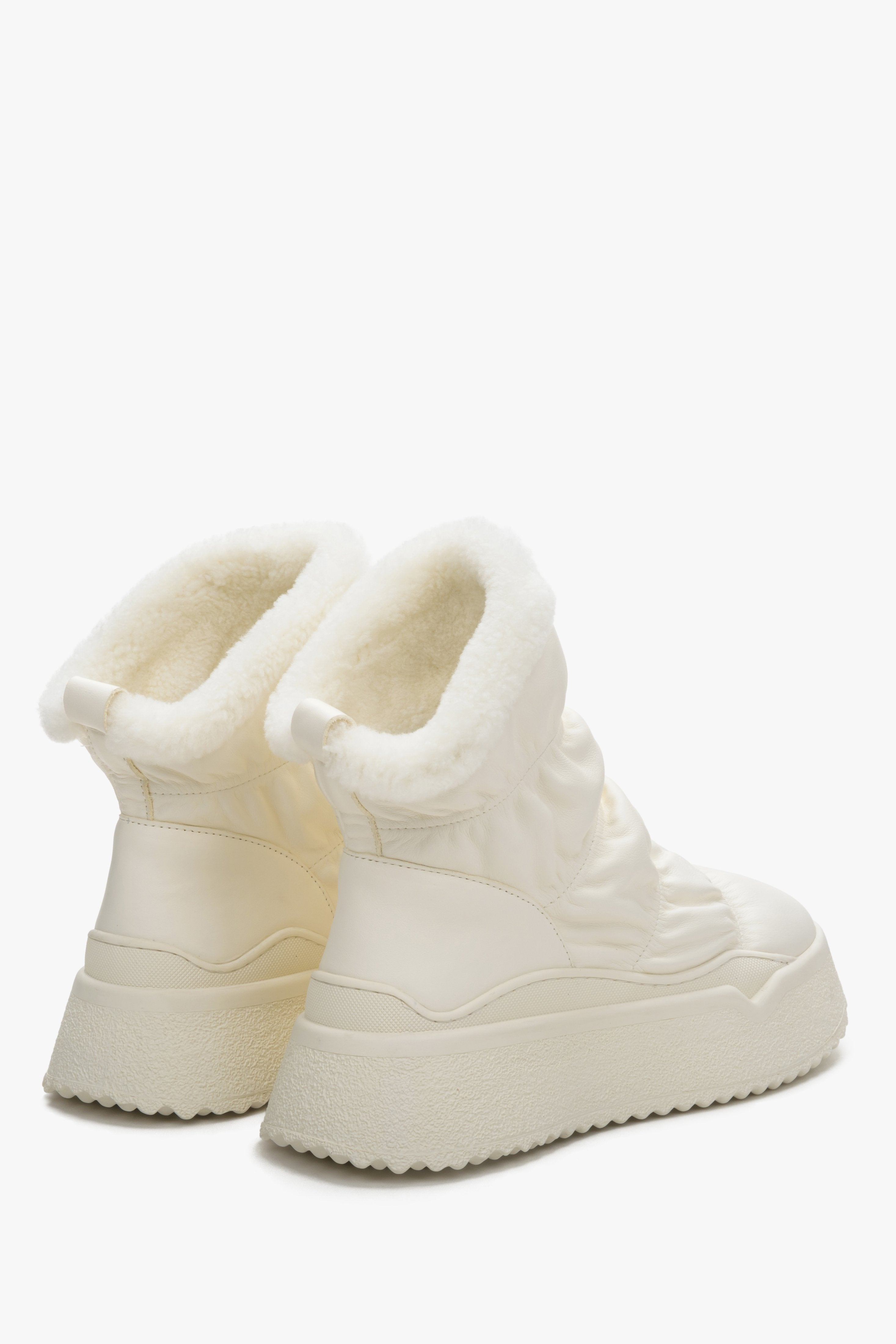 Damskie jasnobeżowe śniegowce ze skóry naturalnej z futrzanym wsadem marki Estro - zbliżenie na zapiętek i linię boczną buta.