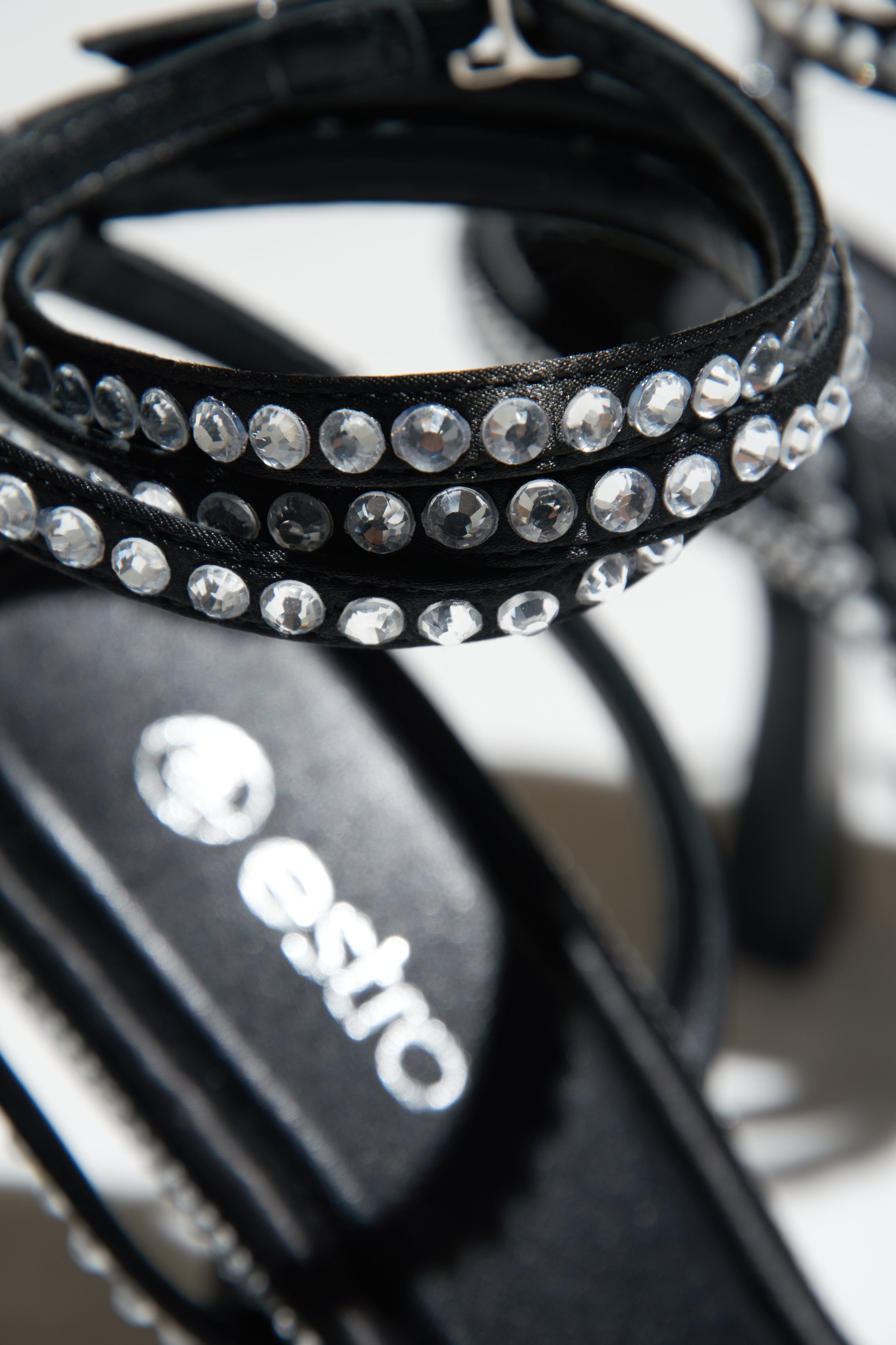 Damskie sandałki na szpilce w kolorze czarnym wysadzane kryształkami - zbliżenie na zdobienia.