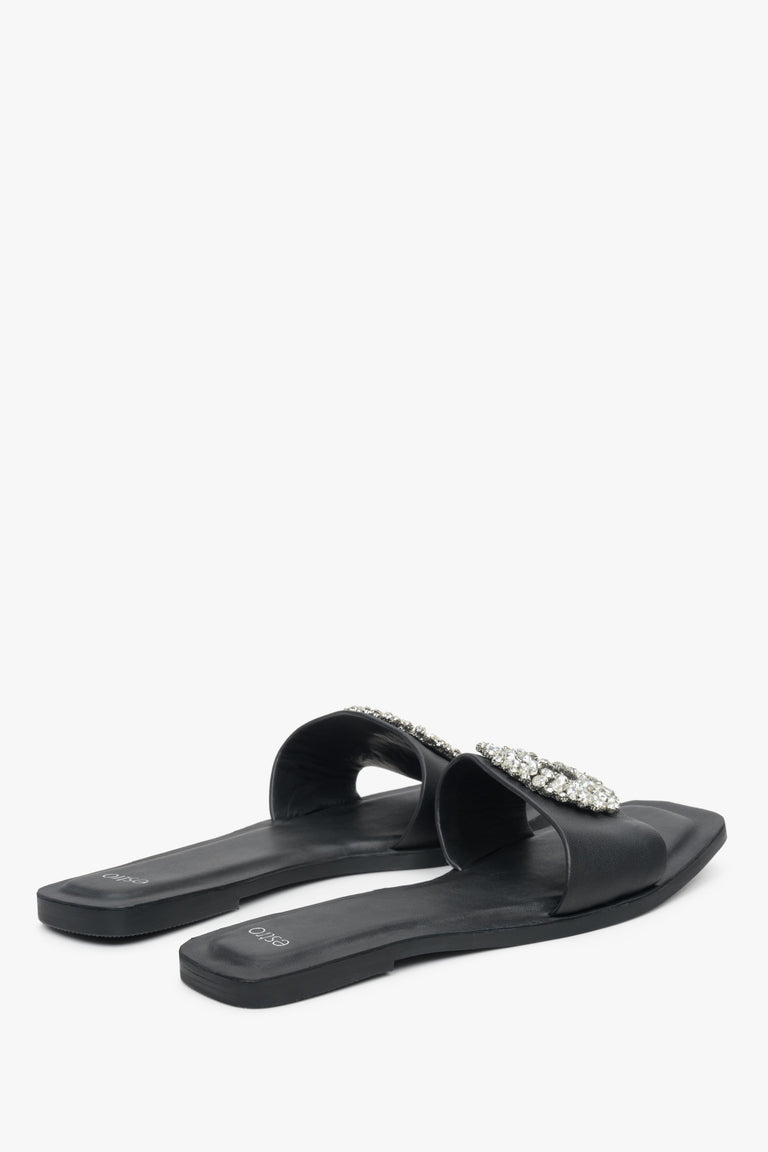 Damskie, skórzane klapki na płaskim obcasie w kolorze czarnym Estro - zbliżenie na linię boczną butów i piętę.