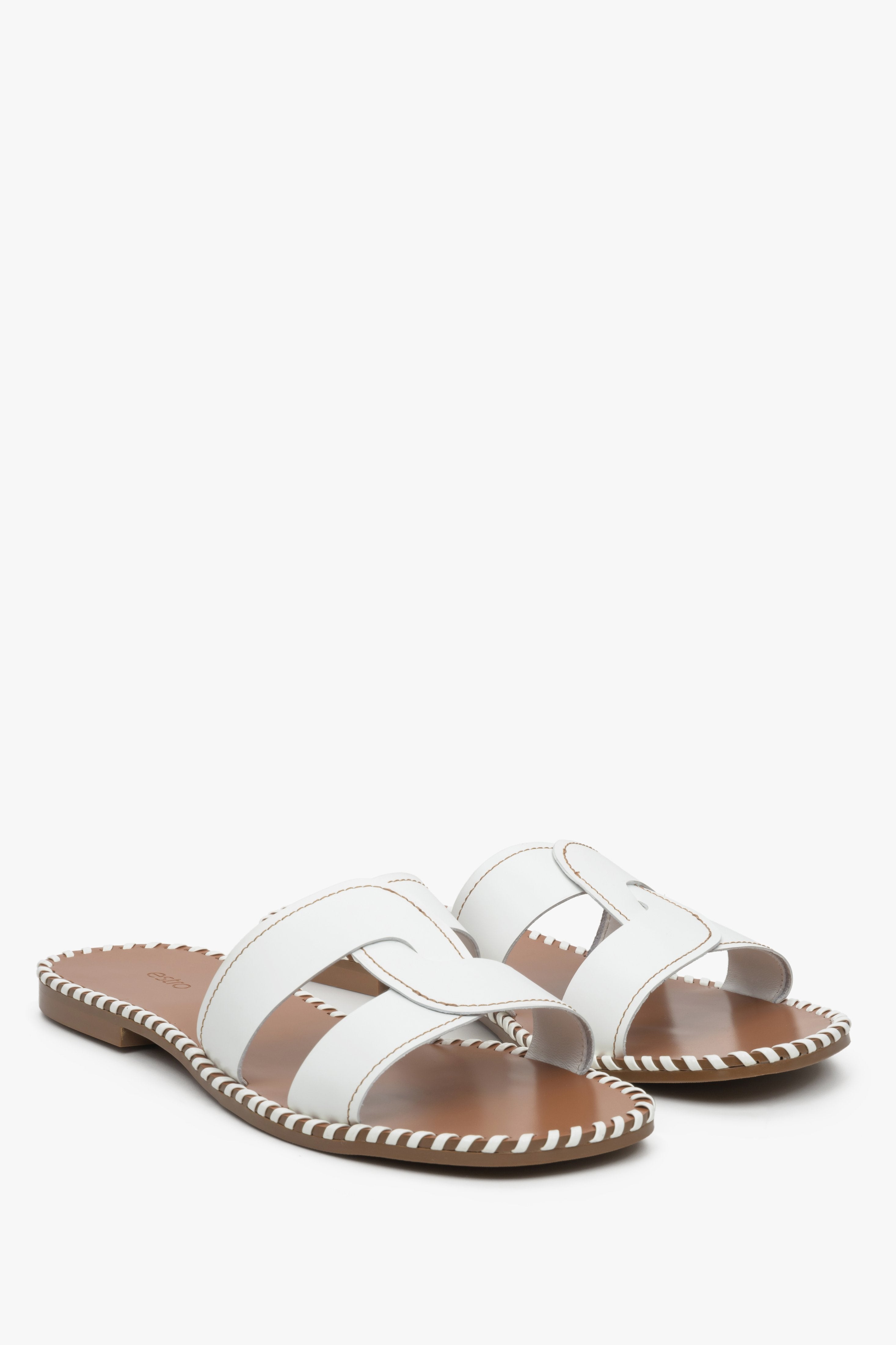 Skórzane klapki damskie na płaskim obcasie Estro w kolorze białym - zbliżenie na linię palców butów.