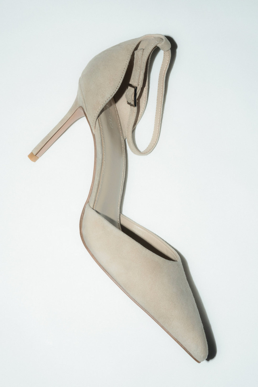 Beżowe buty na obcasie ze sprzączką z weluru naturalnego.