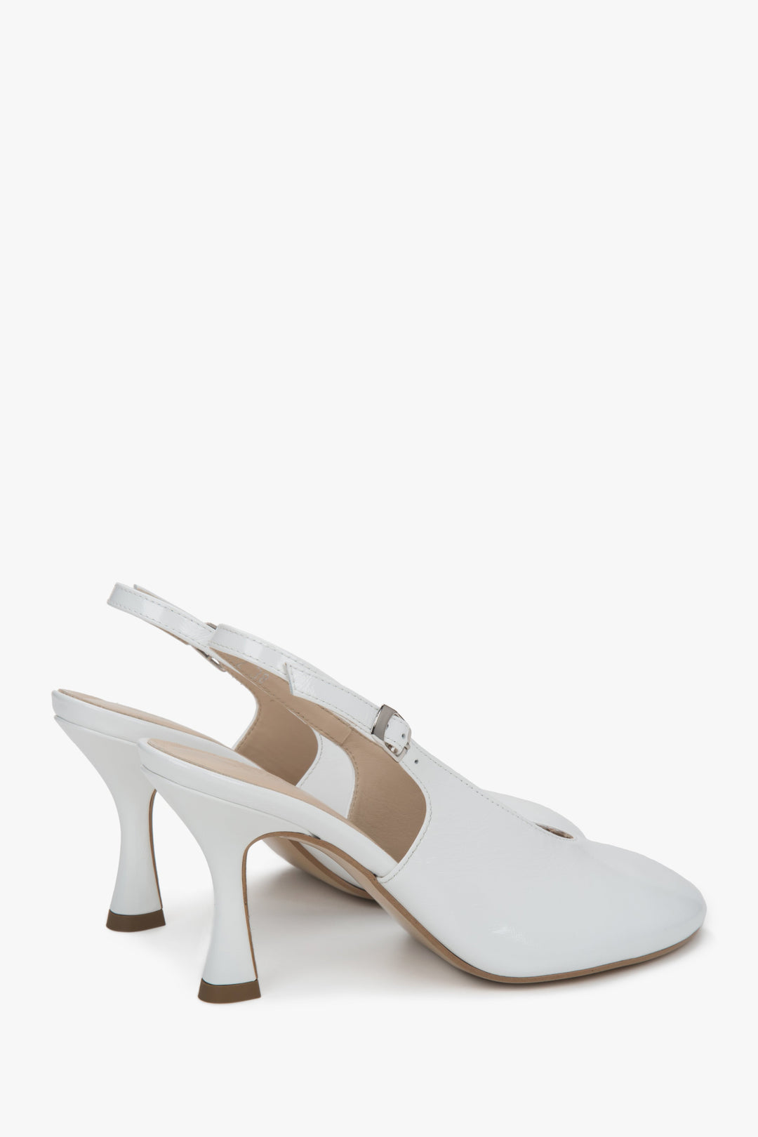 Lakierowane buty damskie typu slingback na obcasie w kolorze białym.
