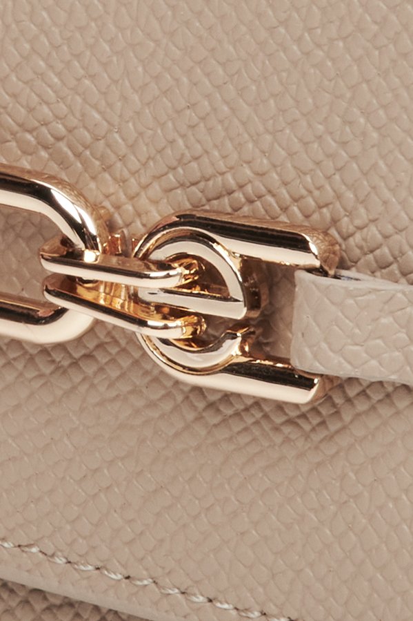 Skórzany, mały portfel damski w kolorze beżowym ze złotą sprzączką - zbliżenie na detale.