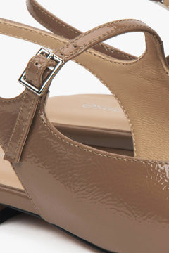 Brązowe sandały damskie typu slingback na płaskim obcasie - zbliżenie na detale.