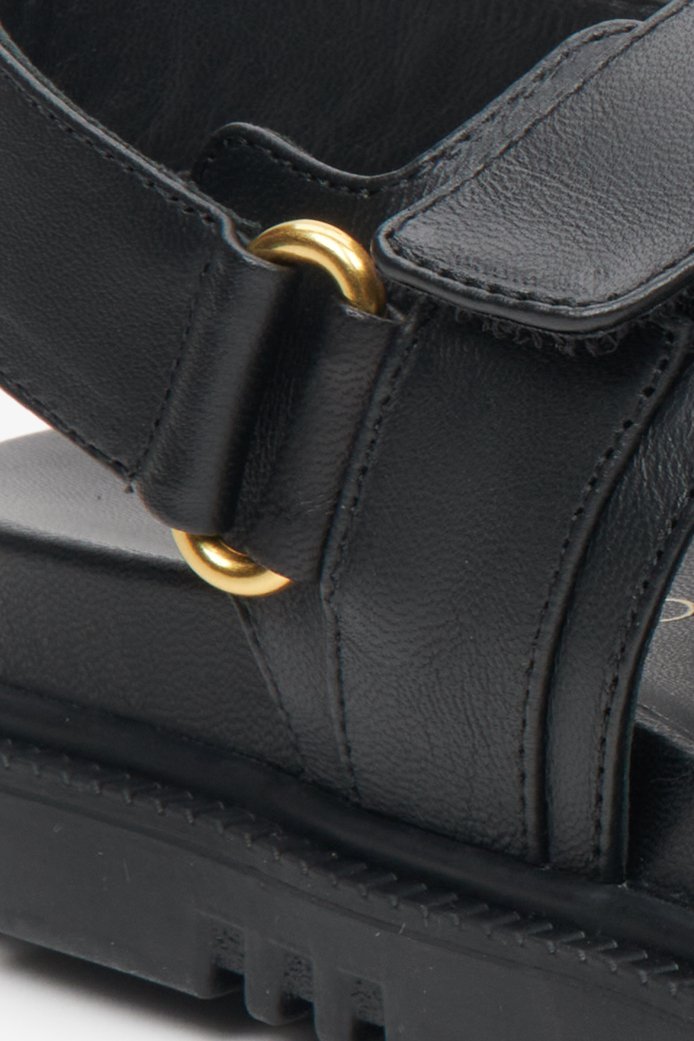 Czarne, skórzane sandały damskie na wygodnej podeszwie ze złotymi elementami - zbliżenie na detale.