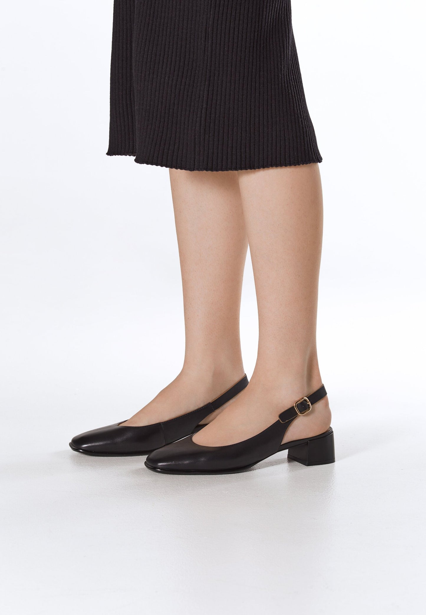 Klasyczne czarne czółenka damskie Estro, typu slingback – prezentacja na nodze.