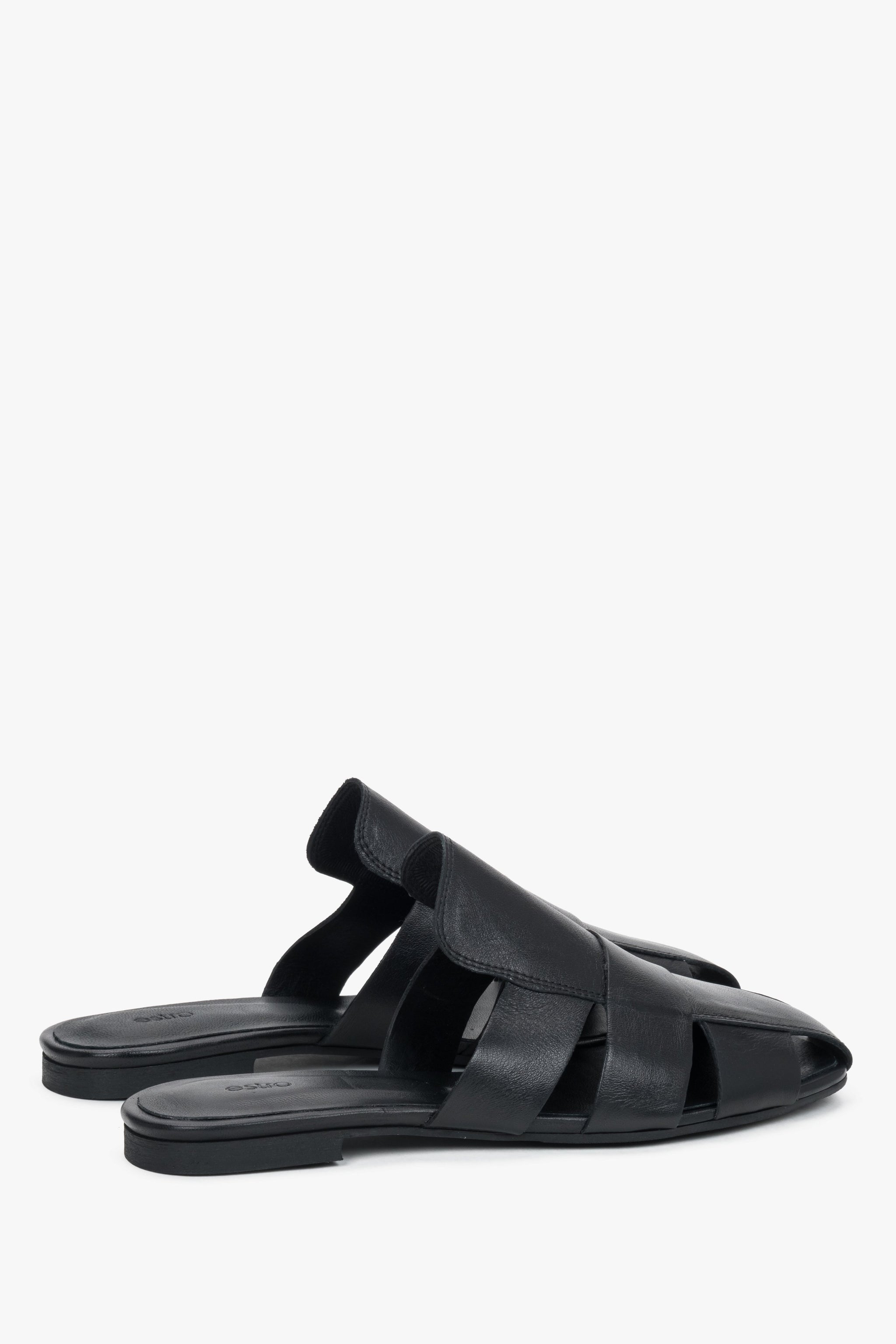 Tył obuwia ukazujący otwartą konstrukcję pięty i precyzyjne, luksusowe wykończenie krawędzi czarnej skóry licowej.