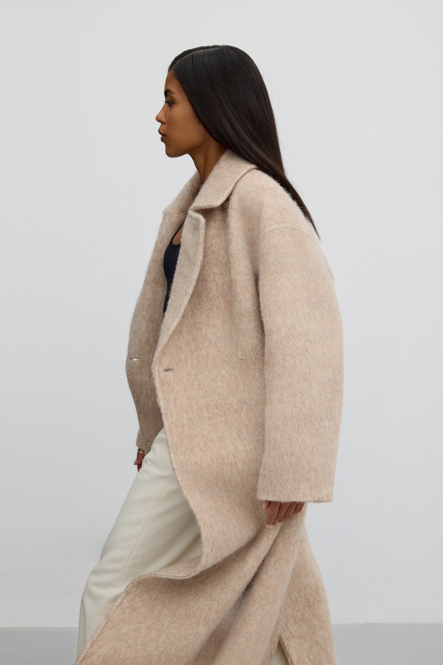 Długi płaszcz damski w kolorze beżowym z wełny naturalnej z pasem Estro ER00115601 - prezentacja z boku.