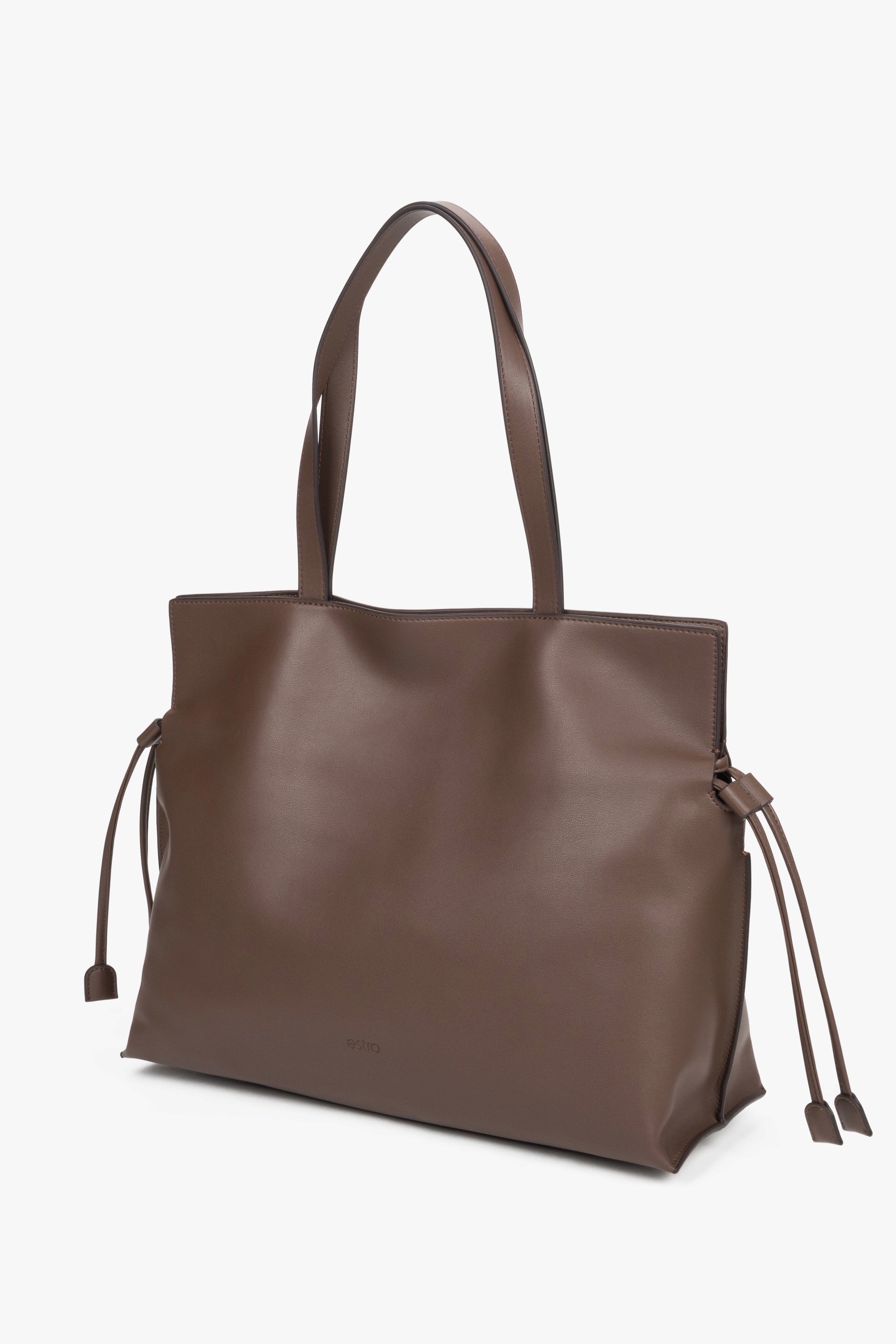 Skórzana torba shopper o grubości 14 cm z widocznymi luźnymi rzemykami po bokach, ukazująca miękkość i szlachetną strukturę gładkiej skóry.