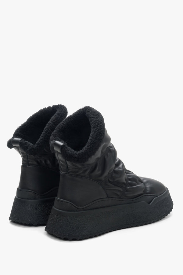 Damskie czarne śniegowce ze skóry naturalnej z futrzanym wsadem marki Estro - zbliżenie na zapiętek i linię boczną buta.