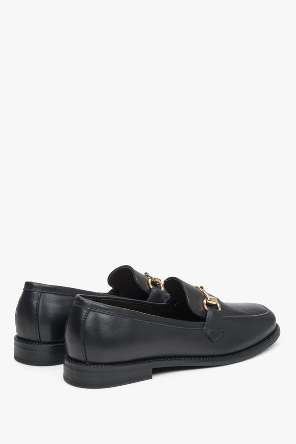 Czarne mokasyny damskie ze skóry naturalnej ze złotą sprzączką - zbliżenie na linię boczną i zapiętek butów.
