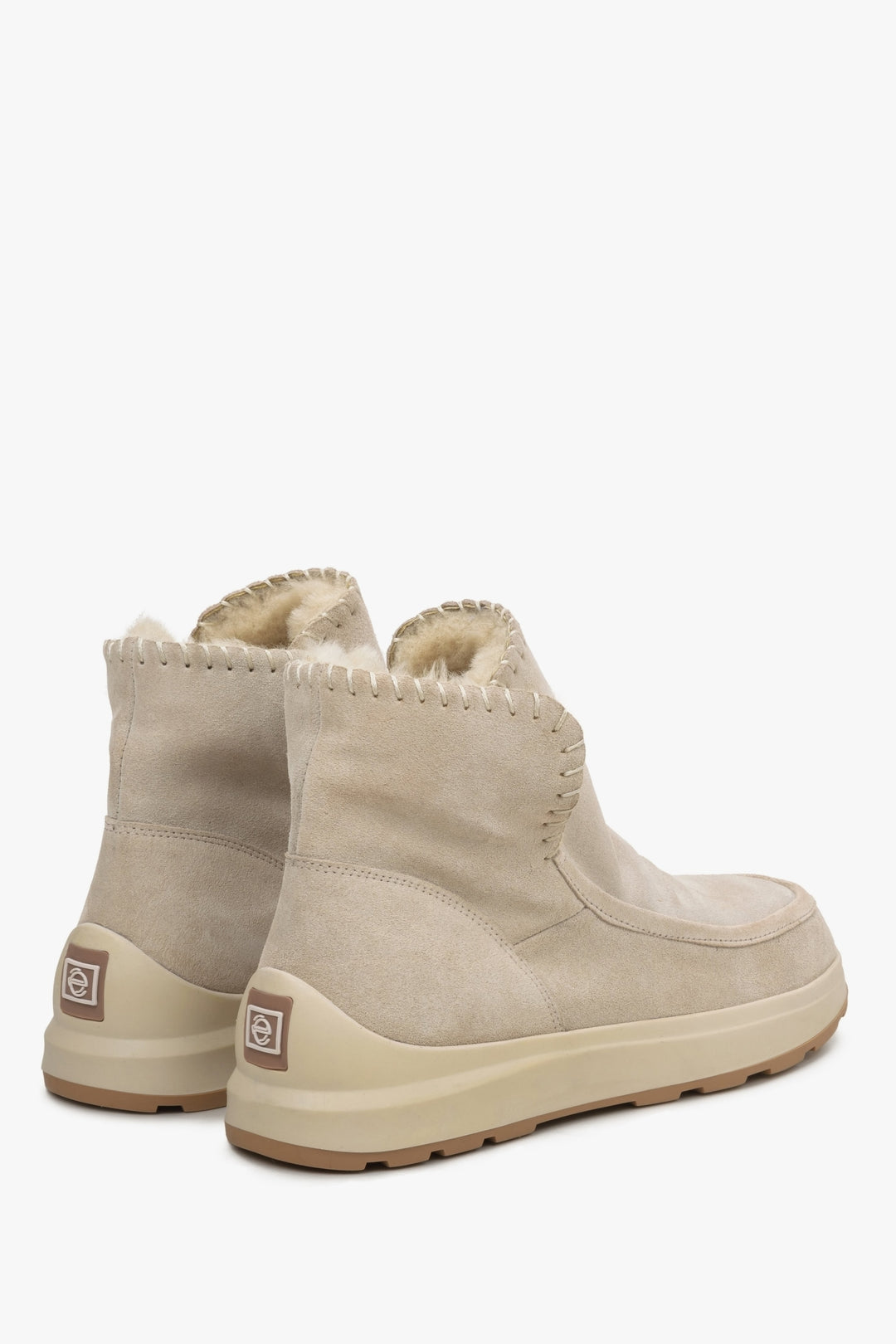 Damskie śniegowce z futra i zamszu naturalnego w kolorze beżowym - zbliżenie na zapiętek i linię boczną butów.