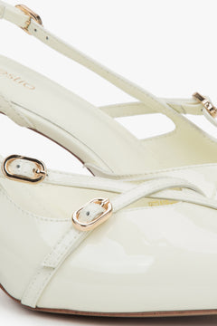 Jasnobeżowe czółenka damskie typu slingback z lakierowanej skóry naturalnej od Estro.