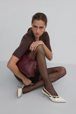 Jasnobeżowe czółenka damskie typu slingback z lakierowanej skóry naturalnej od Estro - prezentacja na modelce. 