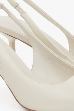 Jasnobeżowe czółenka typu slingback na wysokim obcasie od Estro - zbliżenie na detale.