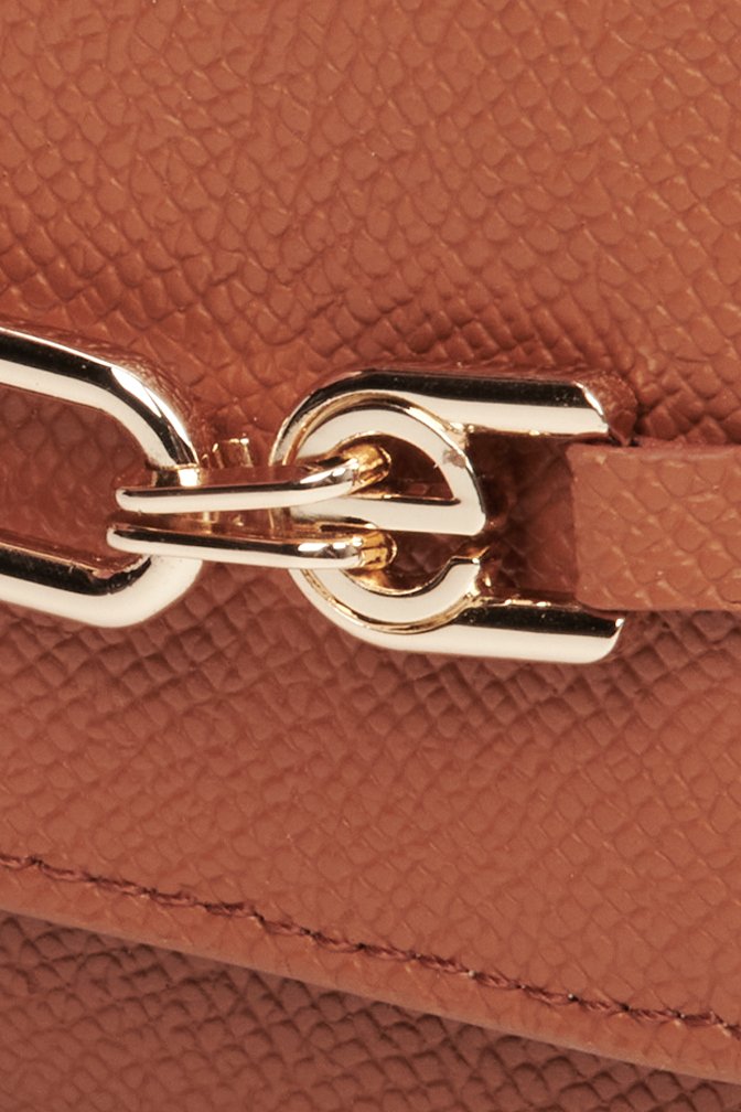 Skórzany, mały portfel damski w kolorze brązowym ze złotą sprzączką - zbliżenie na detale.