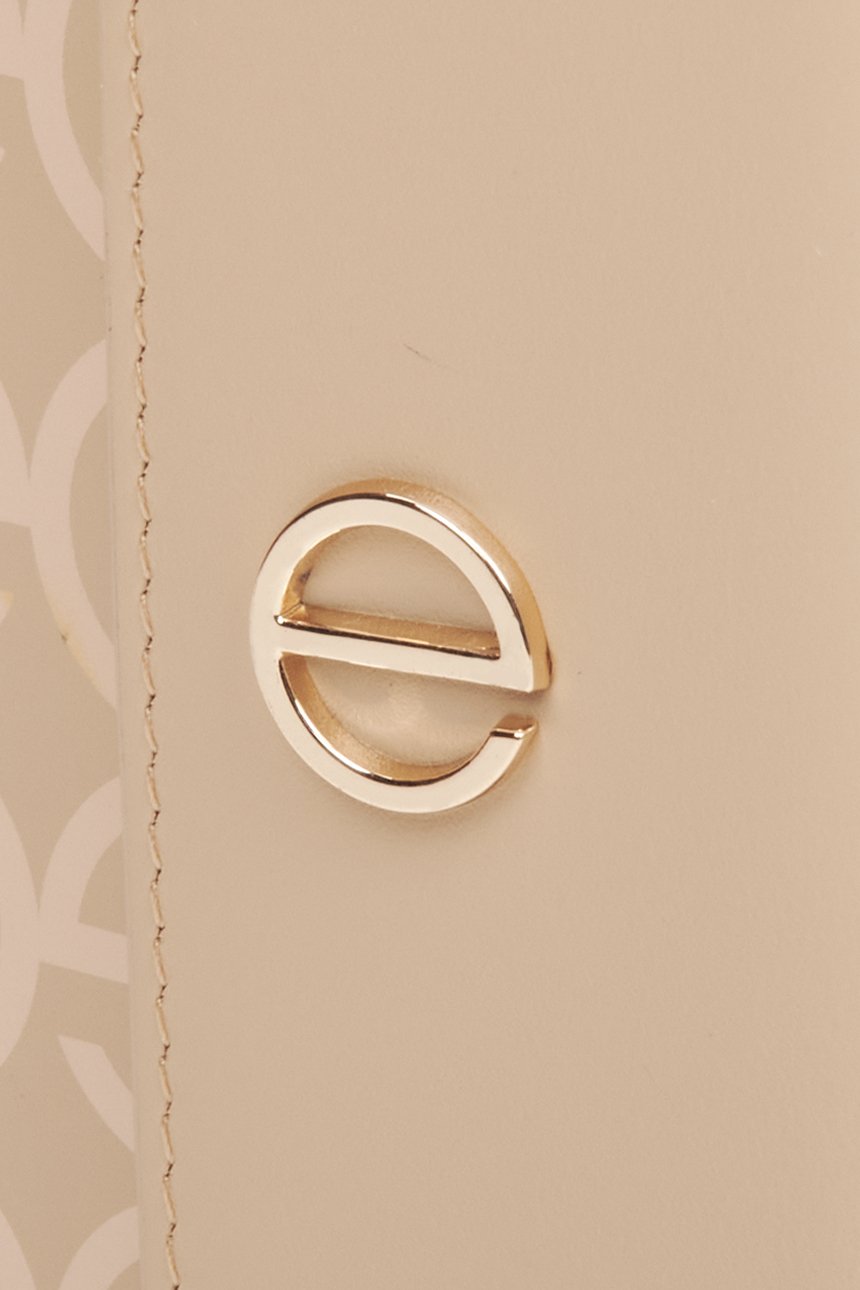 Skórzany portfel damski w kolorze beżowym ze złotymi okuciami marki Estro - zbliżenie na emblemat.