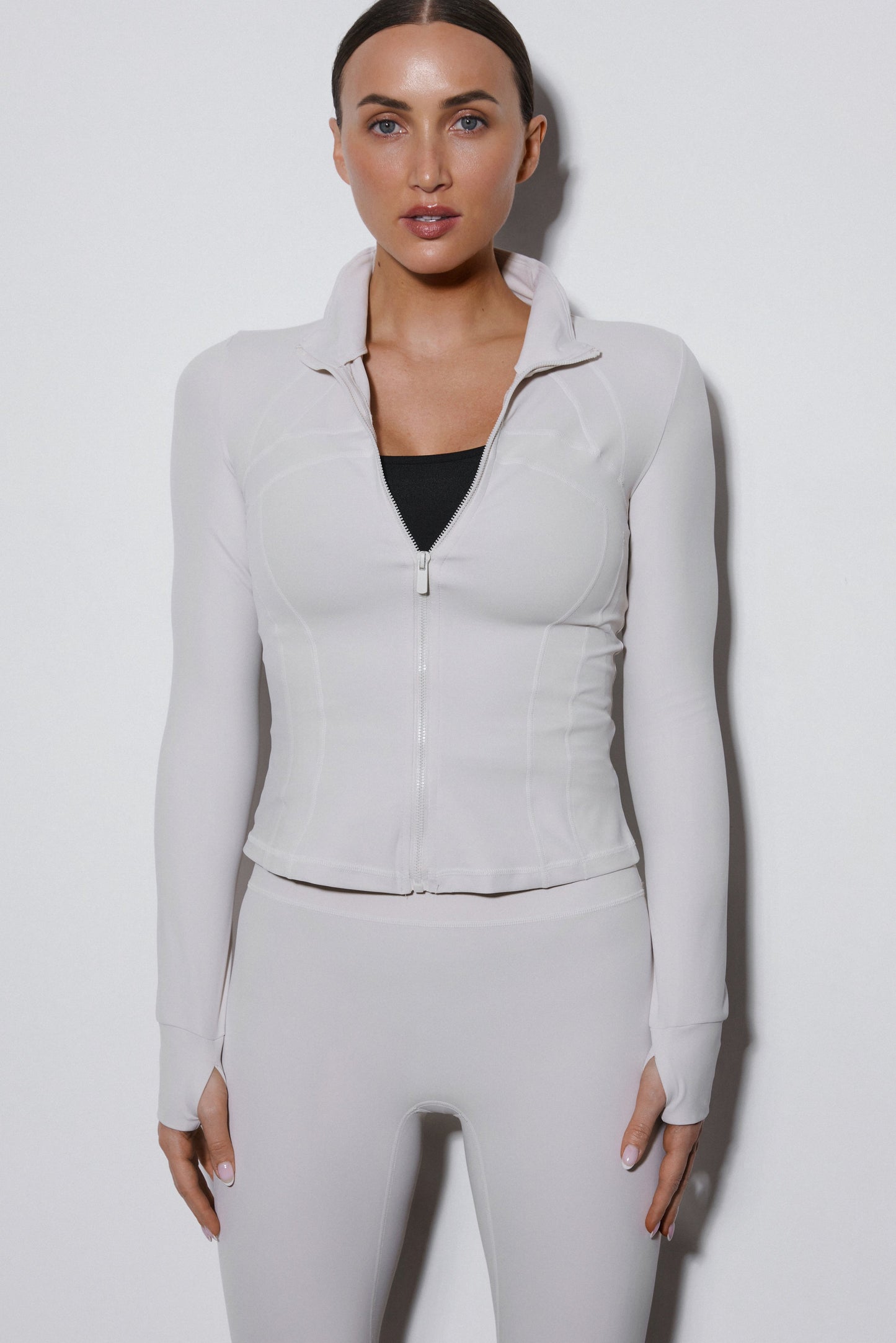 Mlecznobeżowy komplet dresowy Estro składający się z bluzy ze stójką i spodni slim fit.