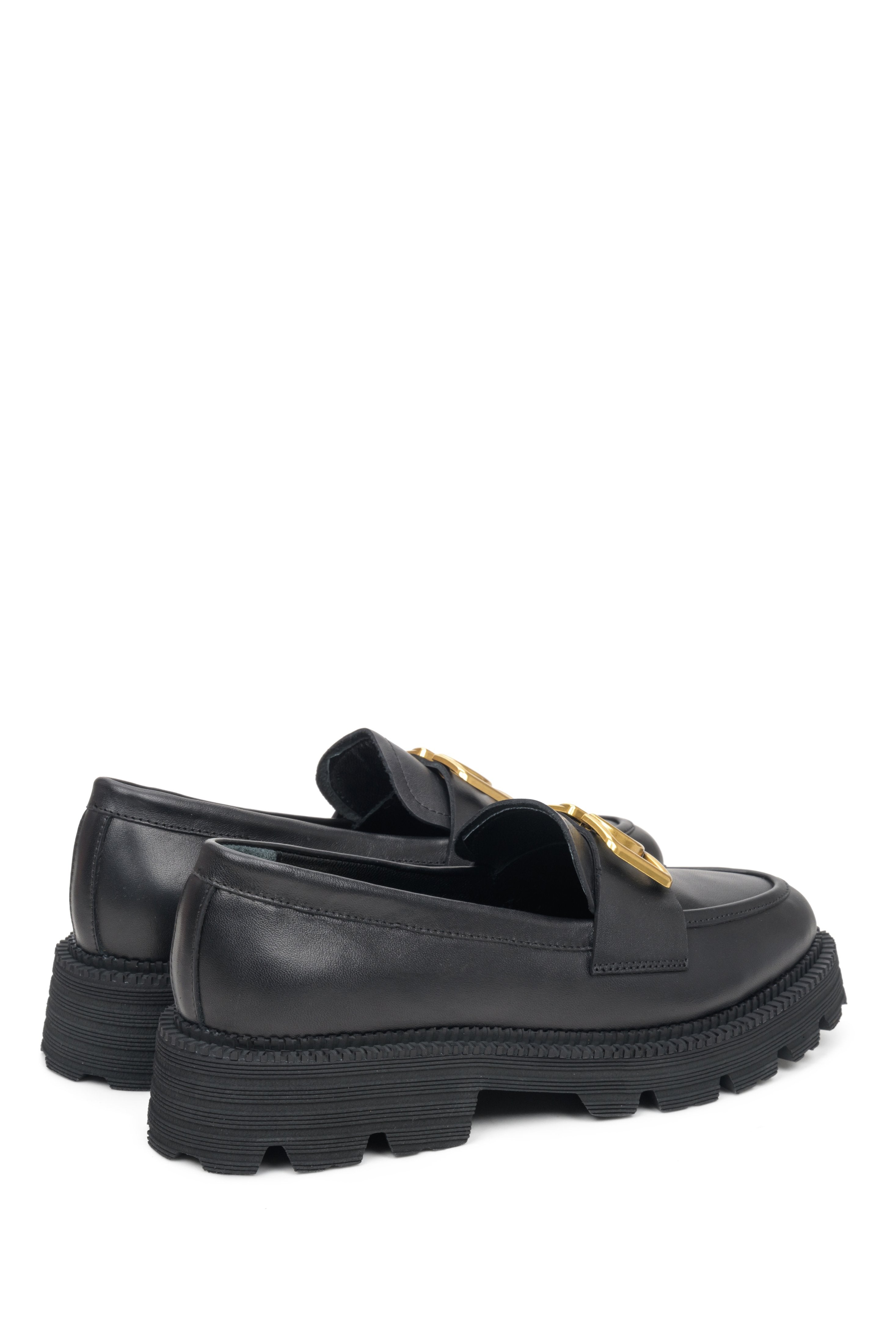 Skórzane mokasyny damskie na grubej podeszwie w kolorze czarnym - zbliżenie na zapiętek i linię boczną buta.