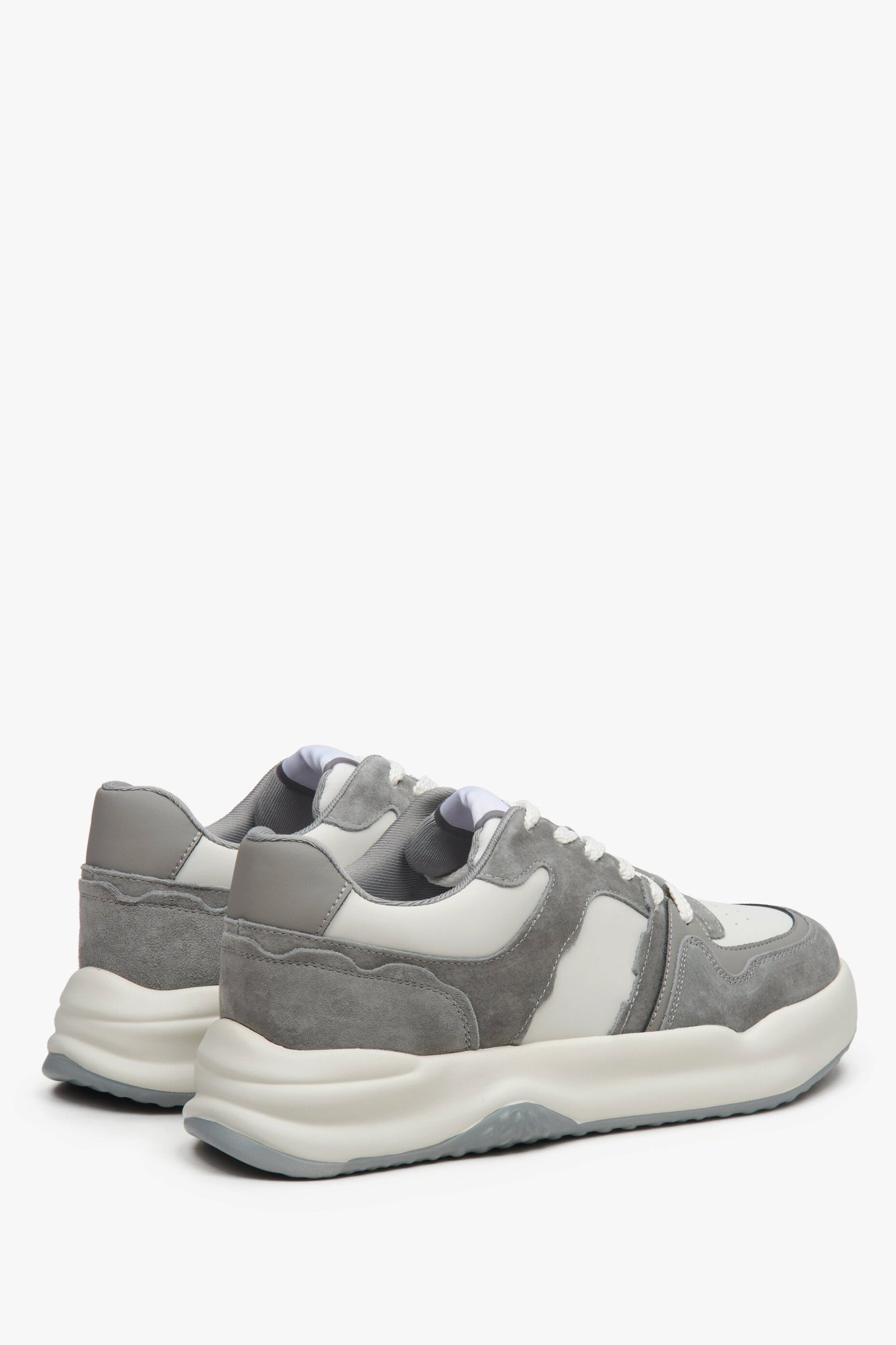 Sneakersy damskie ze skóry naturalnej i zamszu - zbliżenie na zapiętek i przyszwę boczną butów w kolorze szaro-białym.