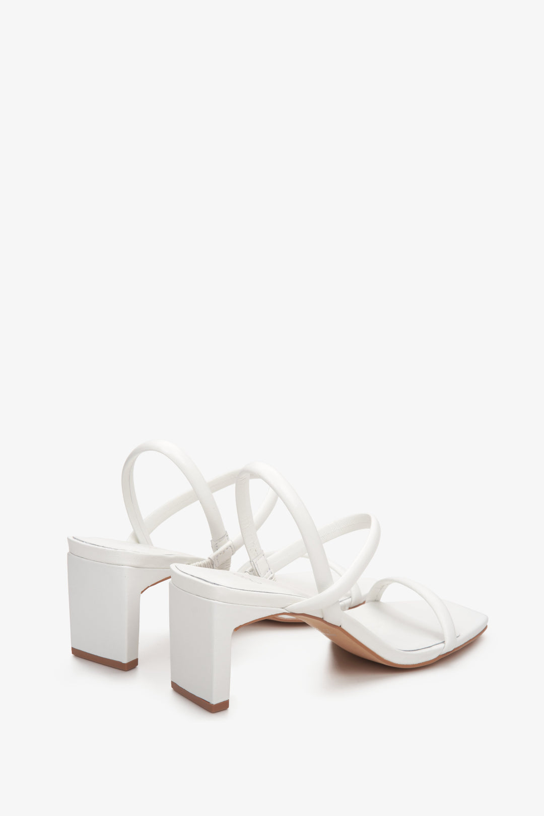 Skórzane, białe sandały damskie na słupku Estro - zbliżenie na linię boczną butów.
