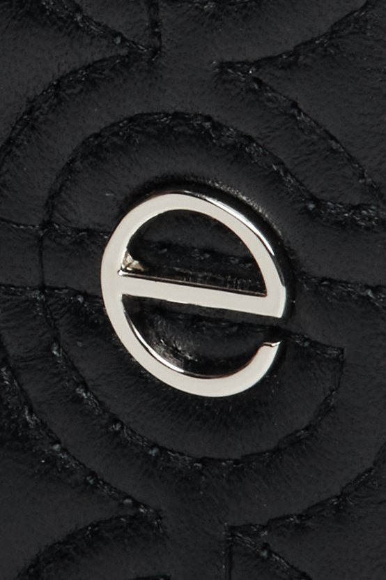 Mały, skórzany portfel damski Estro w kolorze czarnym - zbliżenie na srebrne okucia.