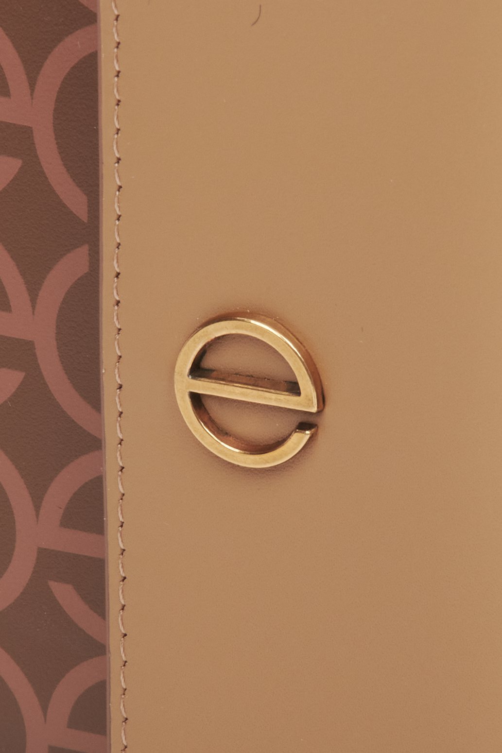 Skórzany portfel damski w kolorze brązowym ze srebrnymi okuciami marki Estro - zbliżenie na emblemat.