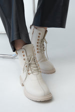 Wysokie botki damskie w kolorze beżowym ze skóry naturalnej ze sznurowaniem marki Estro - prezentacja buta na modelce.