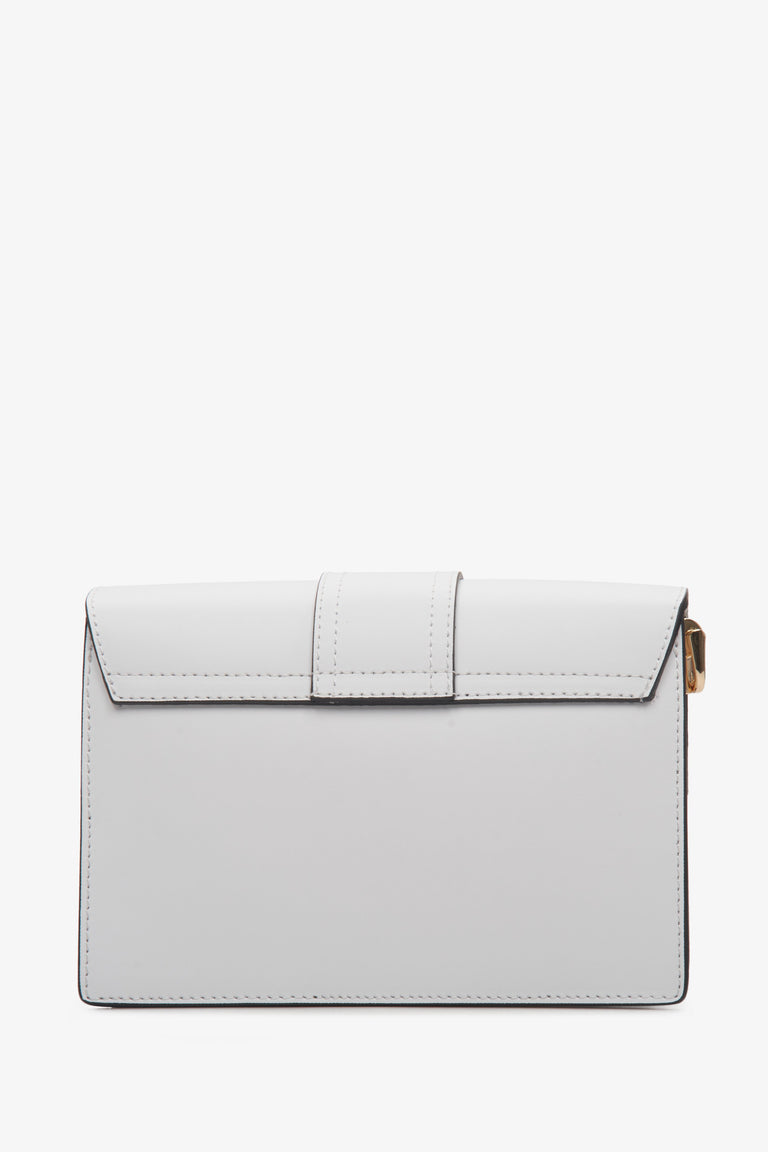 Mała, biała torebka damska produkcji włoskiej na ramię i z dodatkowym paskiem - zbliżenie na tył modelu.