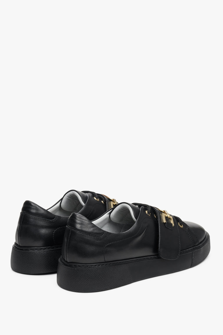 Skórzane, czarne trampki damskie Estro ze złotą aplikacją - zbliżenie na zapiętek i przyszwę boczną butów.