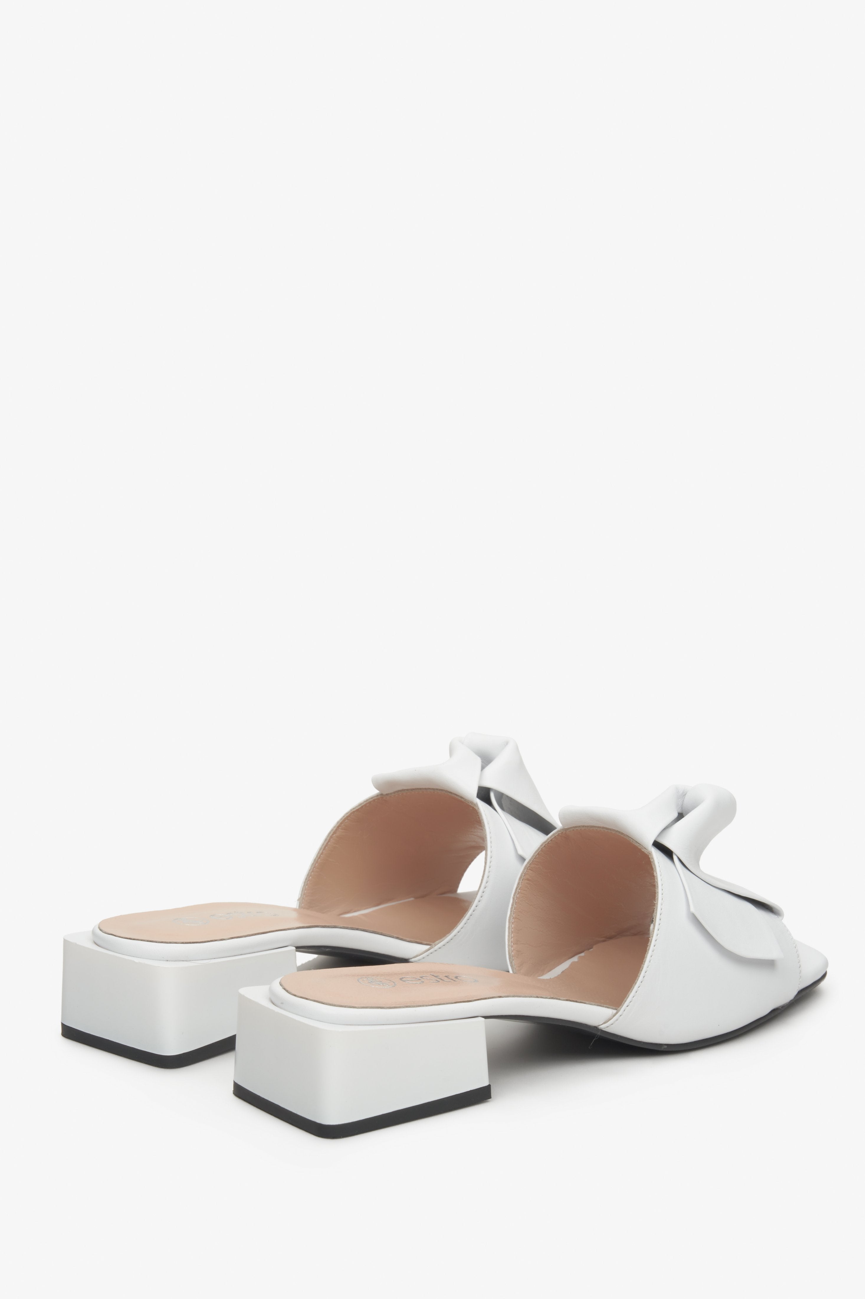 Klapki damskie Estro ze skóry naturalnej w kolorze białym na niskim obcasie - prezentacja obcasa i linii bocznej butów.