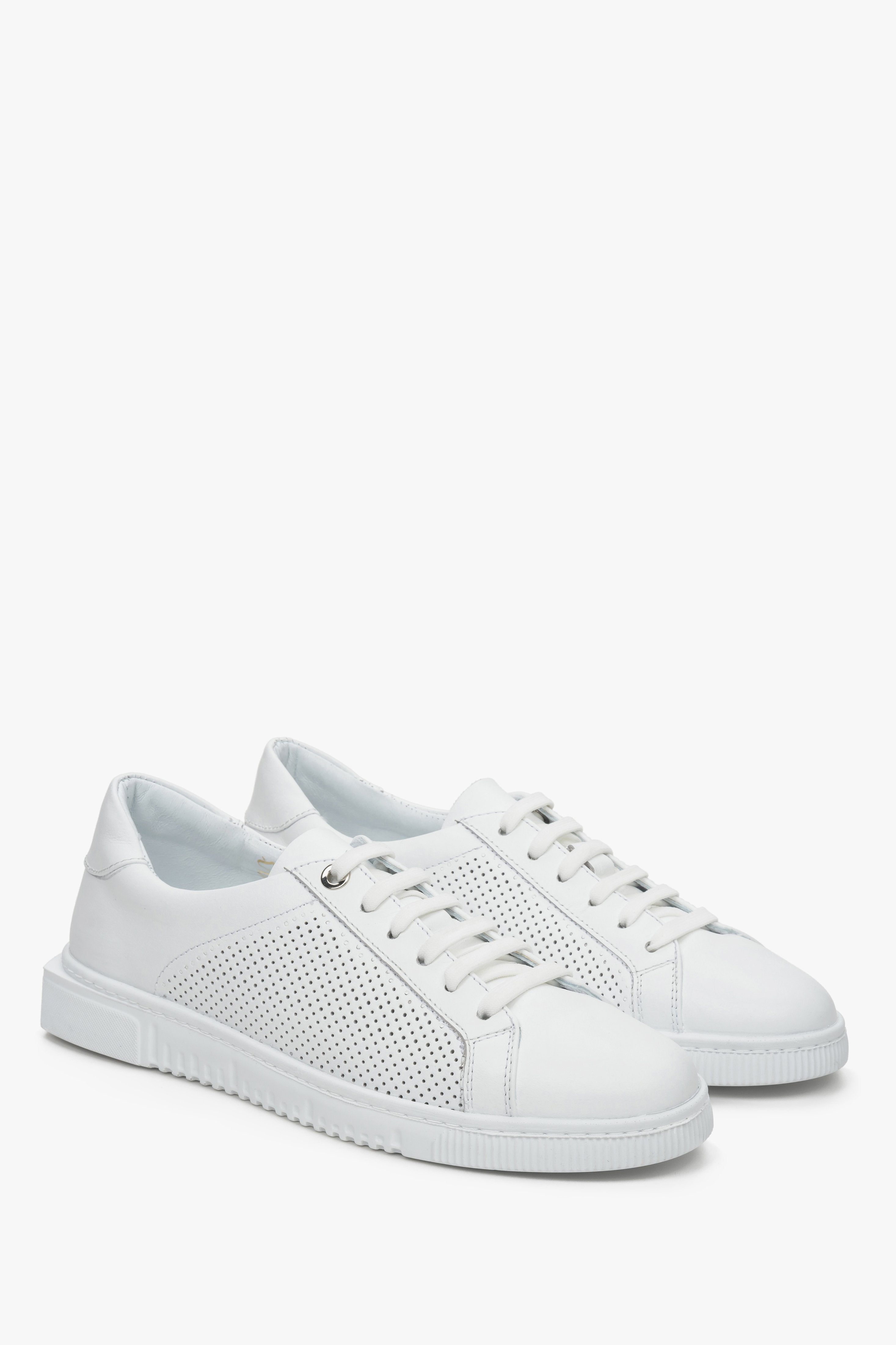 Damskie, białe sneakersy ze skóry naturalnej z perforacją i sznurowaniem - zbliżenie na przyszwę boczną i czubek.