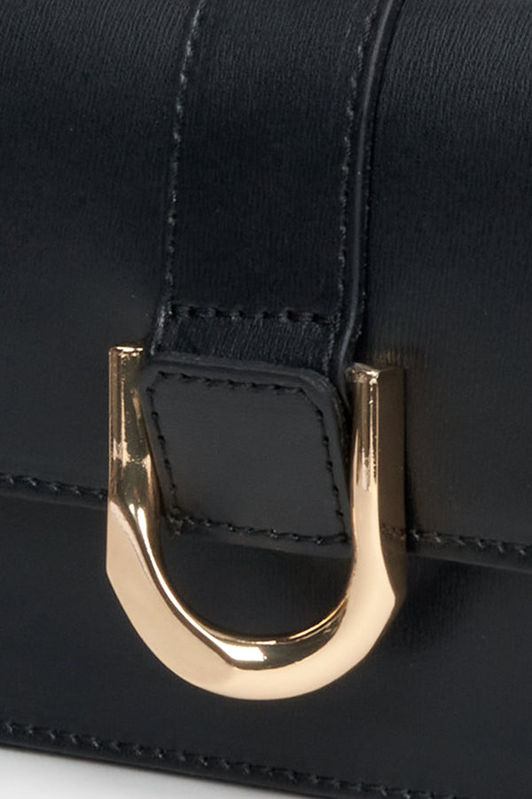 Mała, czarna torebka ze skóry naturalnej marki Estro - zbliżenie na złote detale.
