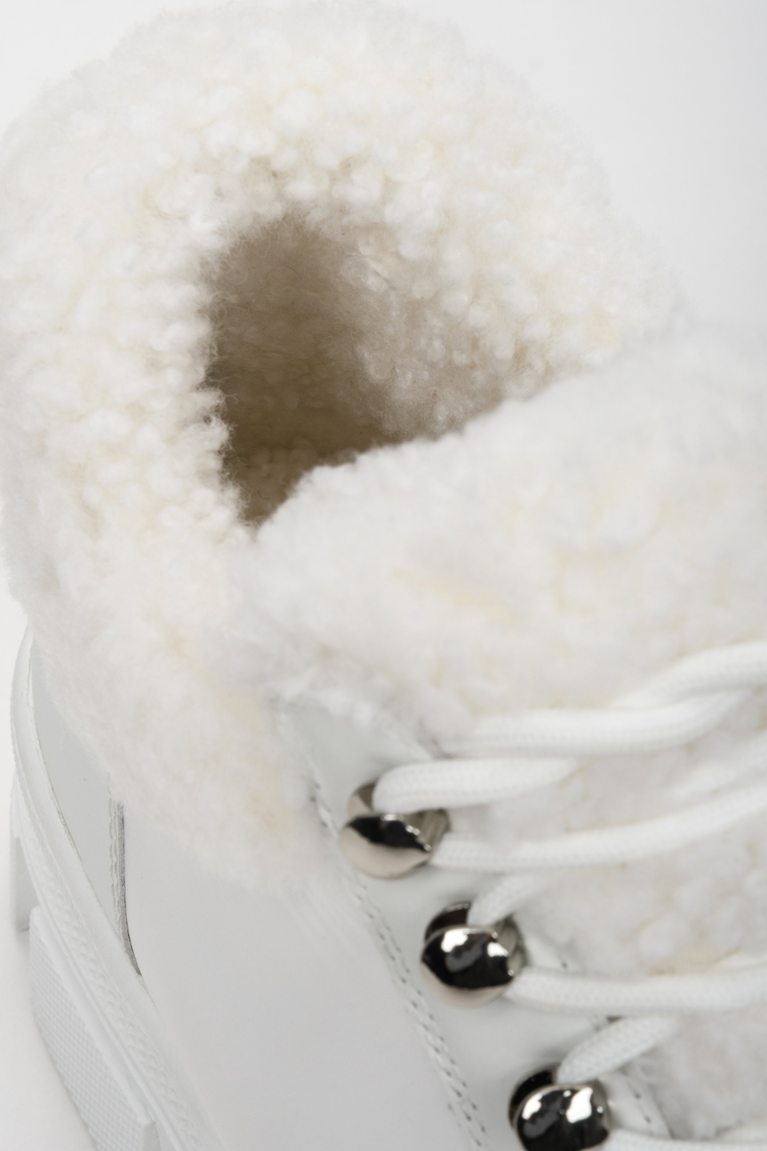 Botki damskie białe ze skóry naturalnej ze sznurowaniem na zimę - zbliżenie na futrzane wypełnienie obuwia.
