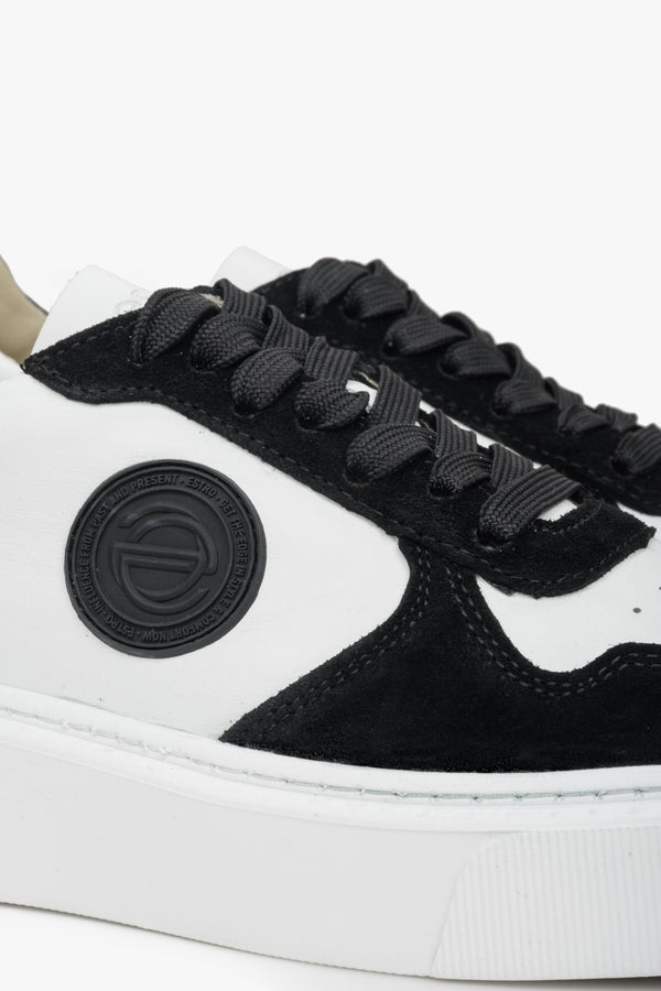 Sneakersy welurowo-skórzane Estro w kolorze biało-czarnym. Zbliżenie na ozdobne logo.
