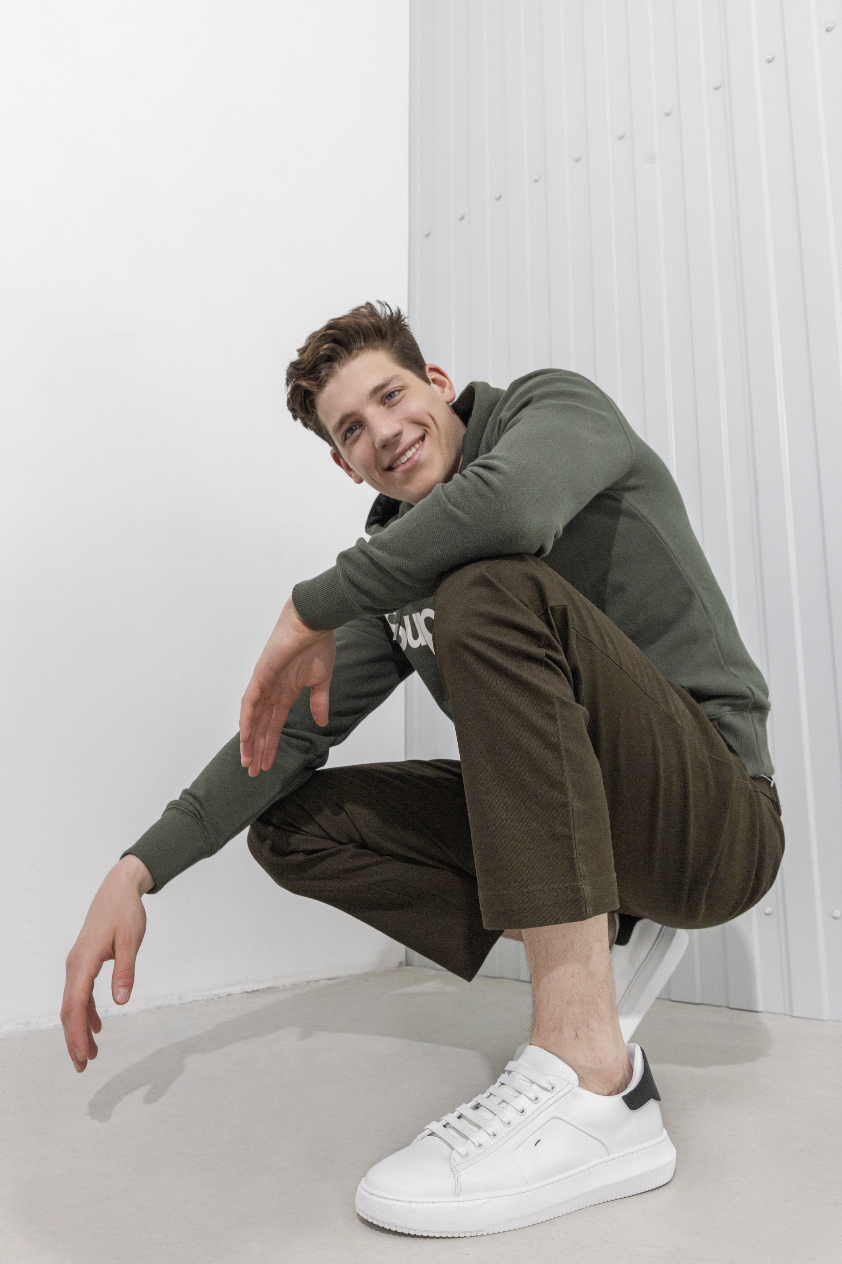 Męskie sneakersy w kolorze białym ze skóry naturalnej marki Estro - wygląd butów na modelu.