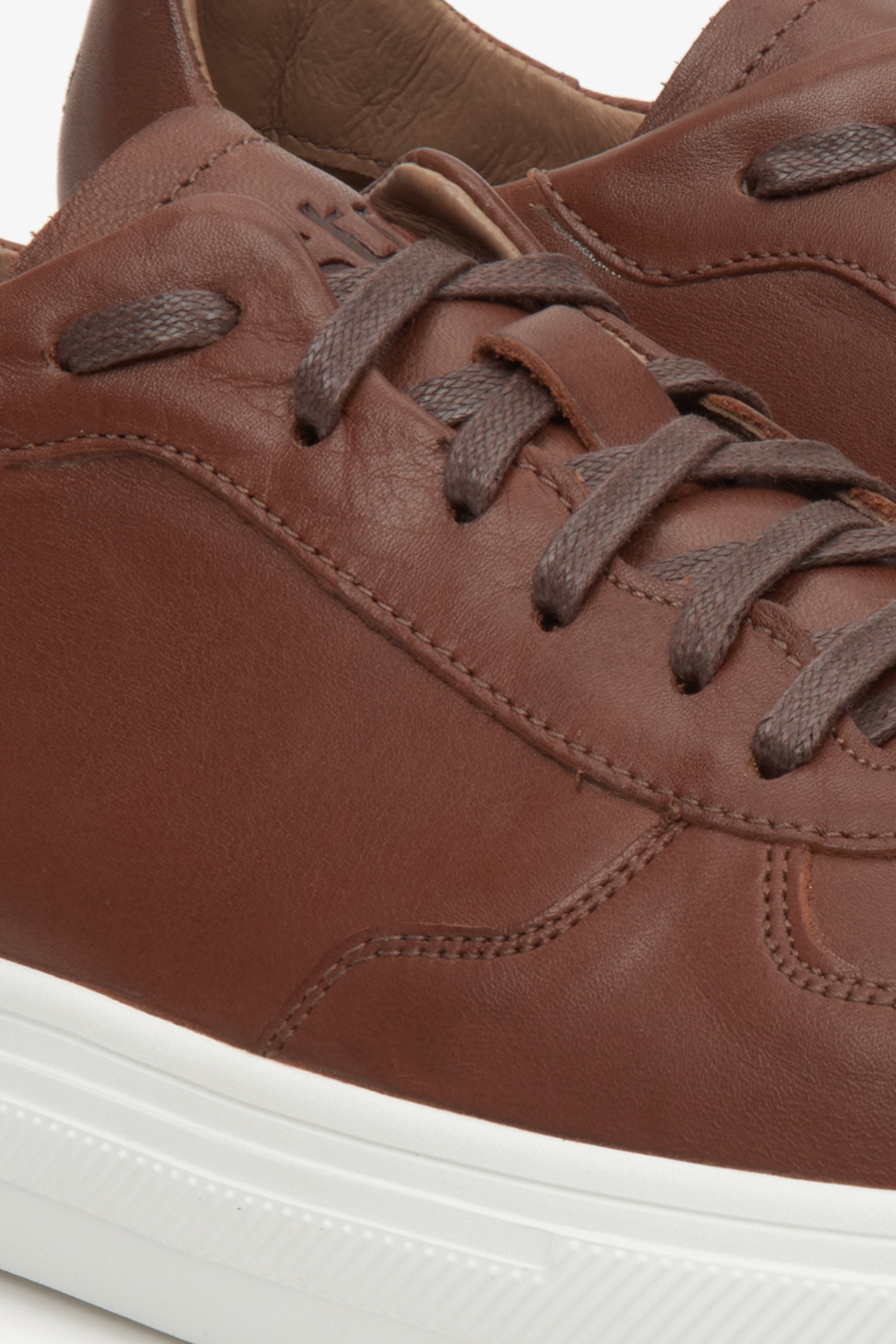 Wiosenne sneakersy męskie Estro w kolorze brązowym - zbliżenie na system sznurowań i przeszyć.